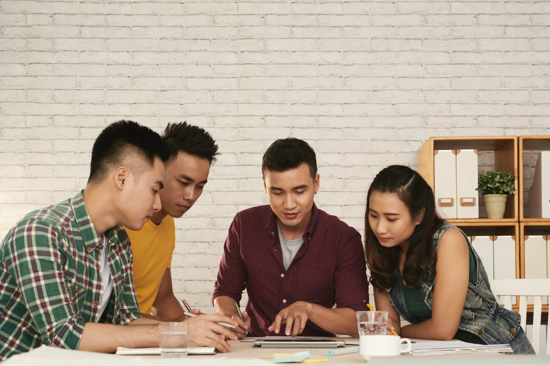 group young men woman standing together around table
