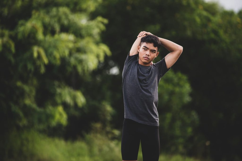 Male runner doing stretching exercise.