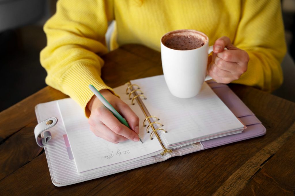 Woman journaling and drinking hot chocolate