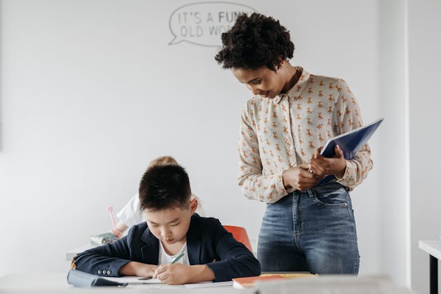 teacher-standing-over-student